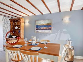 A dining room with a table and chairs at Cottage Sleeps 5 with Parking and Garden in Carreglefn