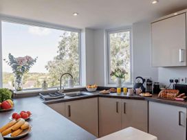 A kitchen with windows and breakfast items at Cottage Sleeps 5 with Parking and Garden in Carreglefn