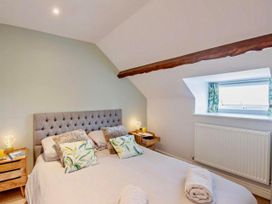 A bedroom with a bed and bedside tables at Cottage Sleeps 5 with Parking and Garden in Carreglefn