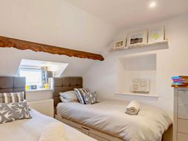 A bedroom with two beds and a shelf in Cottage Sleeps 5 with Parking and Garden Carreglefn