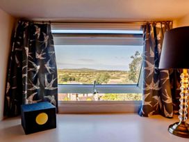 A window with curtains and a lamp at Cottage Sleeps 5 with Parking and Garden in Carreglefn