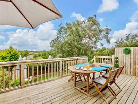 A deck with a table and chairs at Cottage Sleeps 5 with Parking and Garden Carreglefn