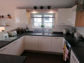 A kitchen with sink and appliances at Seaside Lodge Retreat in Eyemouth