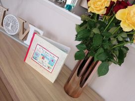 A book and flowers on a table at Seaside Lodge Retreat in Eyemouth