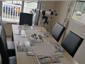A dining room with a table and telescope at Seaside Lodge Retreat in Eyemouth
