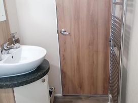 A bathroom with a sink and door at Seaside Lodge Retreat in Eyemouth