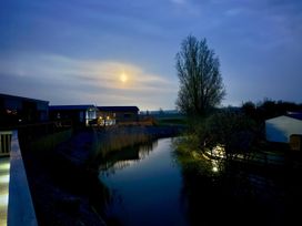 A view of lodges beside a river with a full moon at Malton 2Bed Lodge Sleeps 4 Pet Friendly in Malton