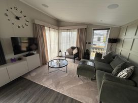 A living room with a clock and television at Malton 2Bed Lodge Sleeps 4 Pet Friendly in Malton