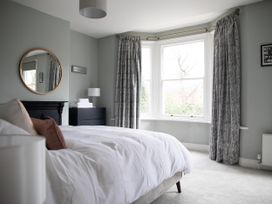A bedroom with a bed, mirror, and window at York Minster 3bed Sleeps 6 Fireplace Free Parking, York