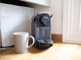 A coffee machine next to a cup at York Minster 3bed Sleeps 6 Fireplace Free Parking, York
