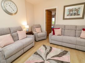 A living room with sofas and a lamp at Biddy Granny's 