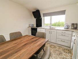 A kitchen with a dining table and chairs at Biddy Granny's