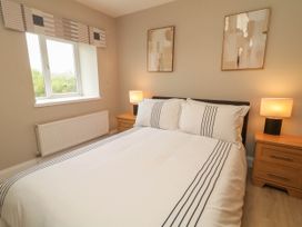 A bedroom with a bed and nightstands at Biddy Granny's