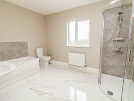 A bathroom with a bathtub, shower, and toilet at Biddy Granny's