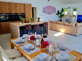 A dining room with a table set for dinner at 4 Bed Villa Sleeps 8 Private Terrace Free parking Near St Austell