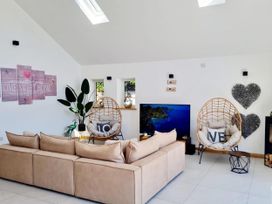 A living room with a sofa and swing chairs at 4 Bed Villa Sleeps 8 Private Terrace Free parking Near St Austell
