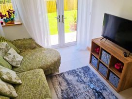 A living room with a sofa and television at 4 Bed Villa Sleeps 8 Private Terrace Free parking near St Austell