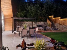 A sitting area with chairs and tables in a garden at 4 Bed Villa Sleeps 8 Private Terrace Free parking Near St Austell