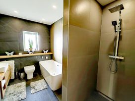 A bathroom with a bathtub and shower at 4 Bed Villa Sleeps 8 Private Terrace Free parking near St Austell