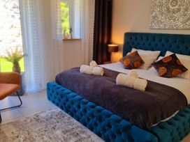 A bedroom with a bed and decorative pillows at 4 Bed Villa Sleeps 8 Private Terrace Free parking Near St Austell