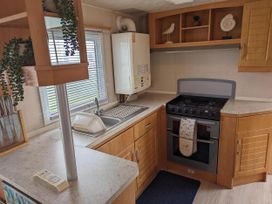 A kitchen with a sink, cooker, and refrigerator at Sandy Paws Dog Friendly Anderby Creek