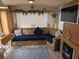 A living room with a sofa and coffee table at Sandy Paws Dog Friendly Anderby Creek