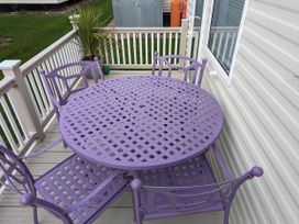 A table and chairs on an outdoor deck at Sandy Paws Dog Friendly Anderby Creek