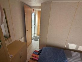 A bedroom with a bed and a door leading outside at Sandy Paws Dog Friendly Anderby Creek