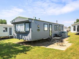 A caravan with a table and chairs outside at 3 Bed Caravan Sleeps 8 Pets Garden Parking in Hull