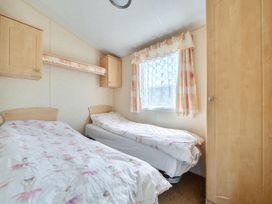 A bedroom with two single beds and a window at 3 Bed Caravan Sleeps 8 Pets Garden Parking Hull