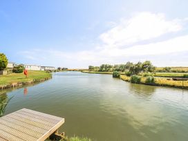 A view of a pond with caravans and greenery at 3 Bed Caravan Sleeps 8 Pets Garden Parking Hull