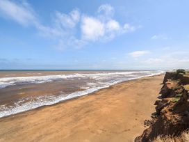 A beach with waves and cliffs at 3 Bed Caravan Sleeps 8 Pets Garden Parking Hull