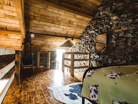 A loft with wooden beams and a bed at The Milking Shed at Pencraig Pet Friendly near Holyhead