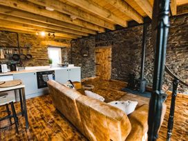 A living room with a kitchen area at The Milking Shed at Pencraig Pet Friendly, Llanynghenedl near Holyhead