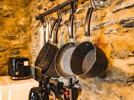 A kitchen with hanging pans and a toaster at The Milking Shed at Pencraig Pet Friendly near Holyhead
