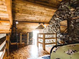 A loft with wooden ceiling and stone walls at The Milking Shed at Pencraig Pet Friendly near Holyhead