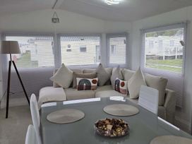 A snug with a sofa and dining table at Luxury Cosy Caravan in Cresswell Northumberland