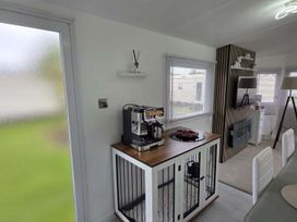 A kitchen area with a coffee machine and dining table at Luxury Cosy Caravan in Cresswell Northumberland
