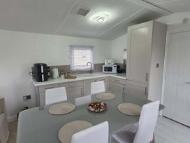A kitchen with a table and chairs at Luxury Cosy Caravan in Cresswell Northumberland