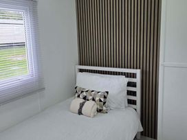 A bedroom with a bed and window at Luxury Cosy Caravan in Cresswell Northumberland