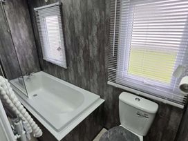 A bathroom with a bathtub and a toilet at Luxury Cosy Caravan in Cresswell Northumberland
