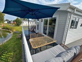 An outdoor terrace with a table and chairs under an umbrella at a property