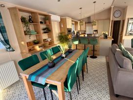 A dining area with a table and chairs in a modern kitchen at a property