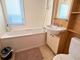 A bathroom with a bathtub, sink, and toilet at The Old Barn in Manchester