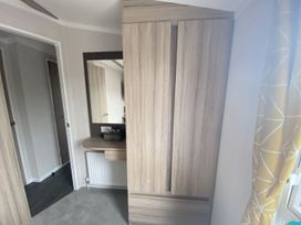 A bedroom with a wardrobe and mirror at The Old Barn in Builth Wells