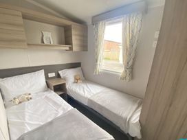 A bedroom with two beds and a shelf at the property in Builth Wells