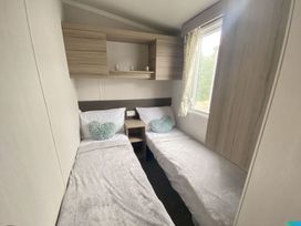 A bedroom with two beds and a window at The Old Barn in Builth Wells