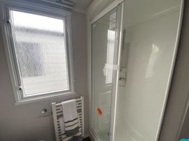 A bathroom with a shower and window at The Old Barn in Builth Wells