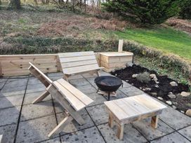 An outdoor seating area with wooden furniture and a fire pit at the property in Builth Wells
