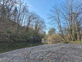 A river surrounded by trees with rocky sand at a scenic location in Builth Wells